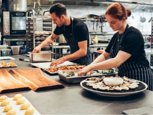 Professional chefs collaborating in a modern commercial kitchen - representing Kitchenly's shared kitchen network